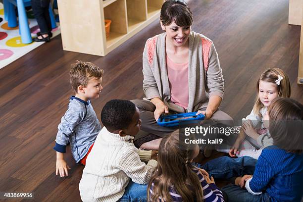 teacher with preschoolers in class sitting on floor - children circle floor stock pictures, royalty-free photos & images