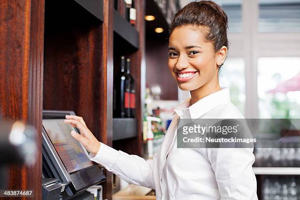 waitress preparing bill at cash register in restaurant - formele kleding stockfoto's en -beelden