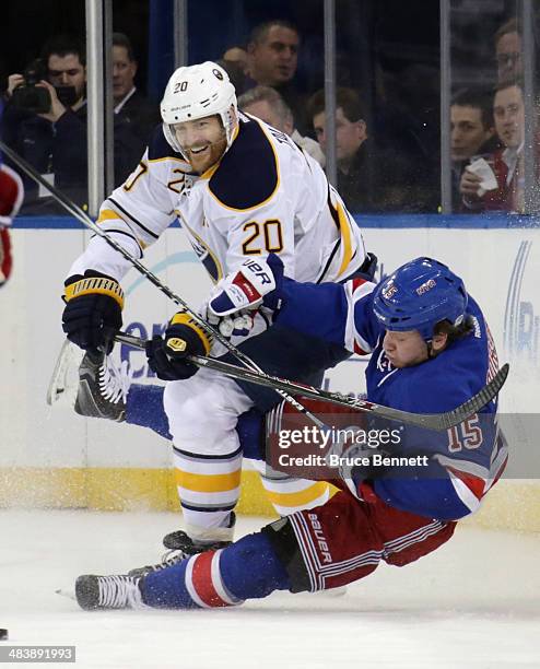 Henrik Tallinder of the Buffalo Sabres trips up Derek Dorsett of the New York Rangers during the first period at Madison Square Garden on April 10,...