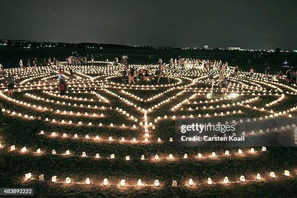 Visitors walks among performances in a labyrinth of 3,000 candles at Tempelhof park on August 13, 2015 in Berlin, Germany. The maze, called "Die...