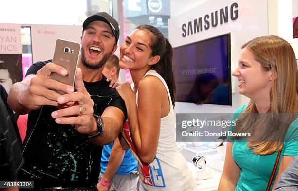 Luke Bryan takes a selfie with fans using the new Galaxy S6 edge+ at the T-Mobile Times Square store in New York to celebrate the unveiling of...