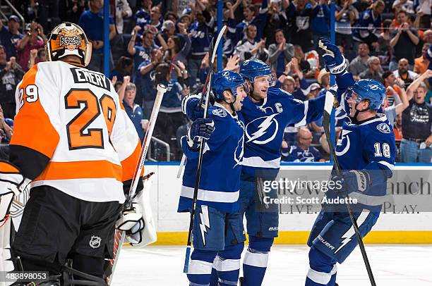 Tyler Johnson of the Tampa Bay Lightning celebrates his goal with teammates Steven Stamkos and Ondrej Palat against goalie Ray Emery of the...