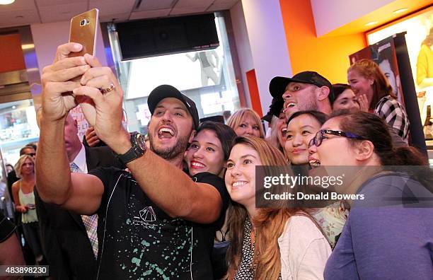 Luke Bryan takes a selfie with fans using the new Galaxy S6 edge+ at the AT&T store in New York to celebrate the unveiling of Samsungs newest...