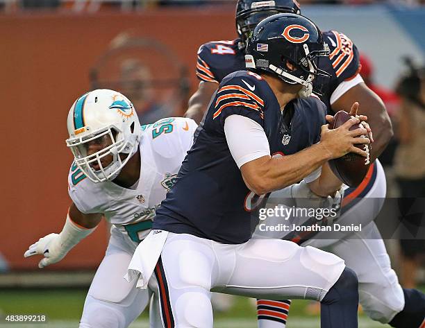 Jay Cutler of the Chicago Bears gets away from Olivier Vernon of the Miami Dolphins during a preseason game at Soldier Field on August 13, 2015 in...