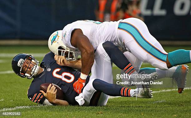 Jay Cutler of the Chicago Bears is hit by Cameron Wake of the Miami Dolphins during a preseason game at Soldier Field on August 13, 2015 in Chicago,...