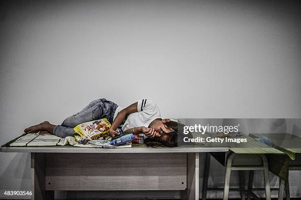 Woman sleeps at the emergency shelter set at a primary school on August 13, 2015 in Tianjin, China. Over 500 injured and evacuated people stay at the...