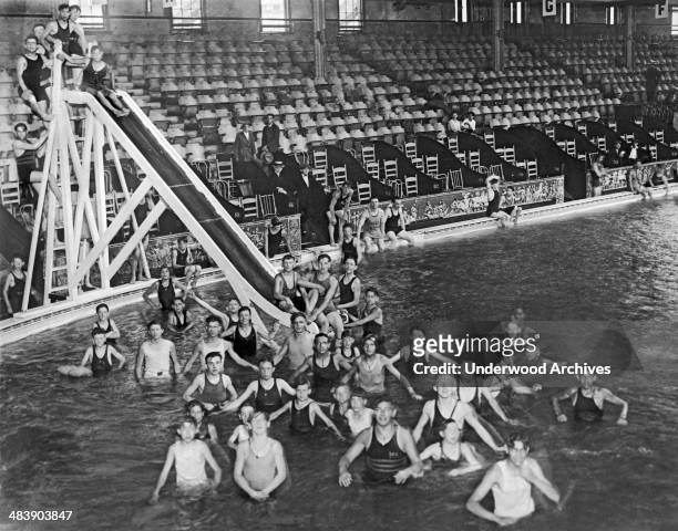 Young men enjoy the opening of the world's largest indoor pool in Madison Square Garden during these sweltering days of July, New York, New York,...
