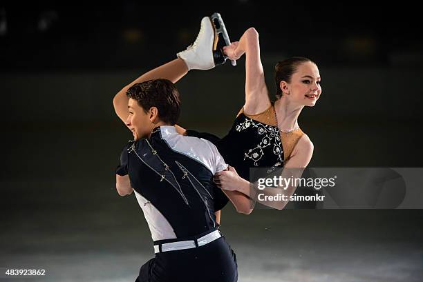 young figure skating pair performing - figure skating stock pictures, royalty-free photos & images