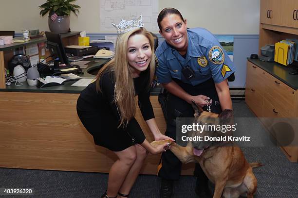 Kira Kazantsev pose for photograph with a member of Hamilton Township Police and shakes hands with the police dog at Hamilton Mall on August 13, 2015...