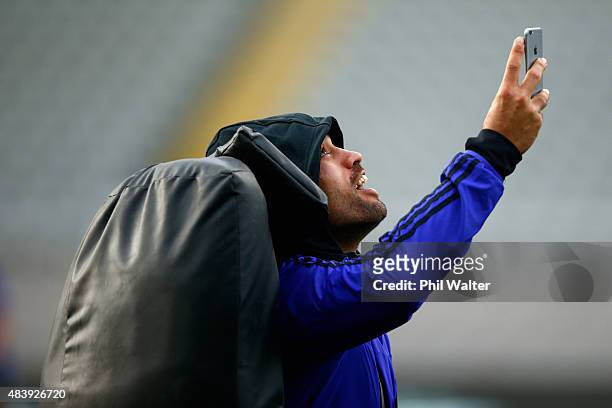 Liam Messam of the All Blacks takes a selfie on a smart phone during a New Zealand All Blacks Captain's Run at Eden Park on August 14, 2015 in...