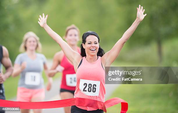 weibliche läufer gewinnen marathon-rennen - marathon ziel stock-fotos und bilder