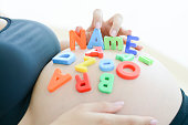 expectant mother spelling name on her pregnant belly