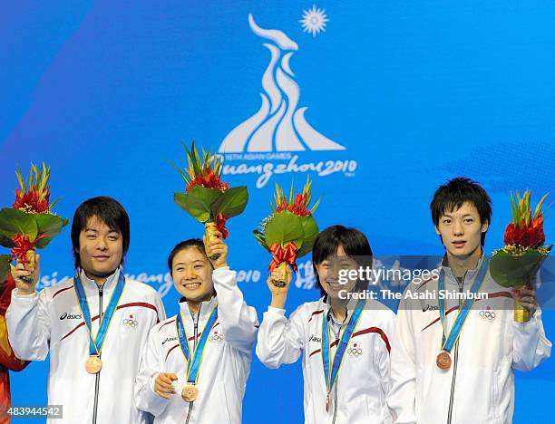 Bronze medallists Seiya Kishikawa, Ai Fukuhara, Kasumi Ishikawa and Kenta Matsudaira of Japan celebrate on the podium at the medal ceremony for the...