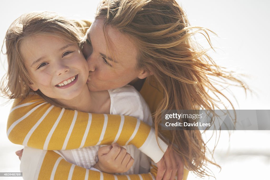 Close up of mother kissing daughter at beach