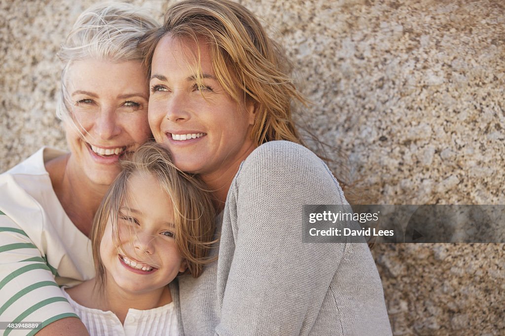 Three generations of women smiling outdoors