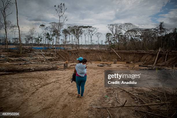 Miners evacuate the camp before policemen set their camp on fire during an operation in illegal gold mining area of La Pampa, in Madre de Dios,...