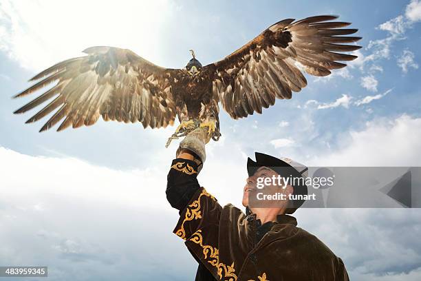 traditional kyrgyz hunter holding eagle - kazakhstan stock pictures, royalty-free photos & images