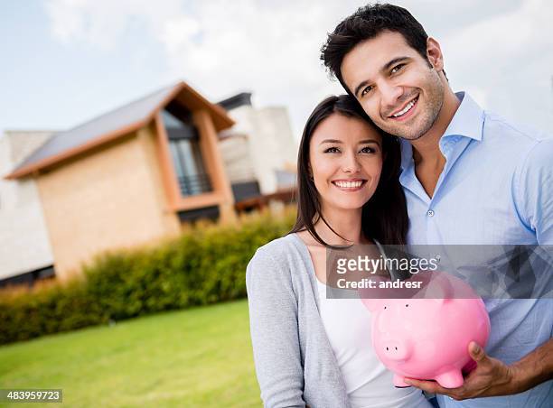 couple saving for their house - couple saving piggy bank stock pictures, royalty-free photos & images