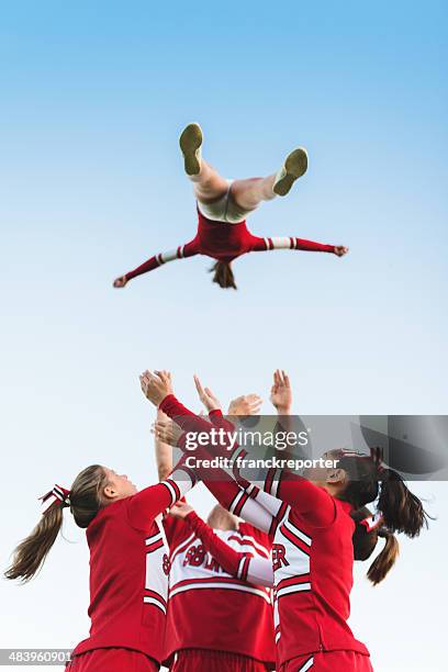 cheerleader throw-up-mädchen in der luft - cheerleading stock-fotos und bilder