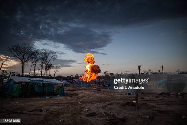 Flames and plumes of black smoke rise over an illegal gold mining camp after authorities set fire to machinery and gasoline used by the miners,...