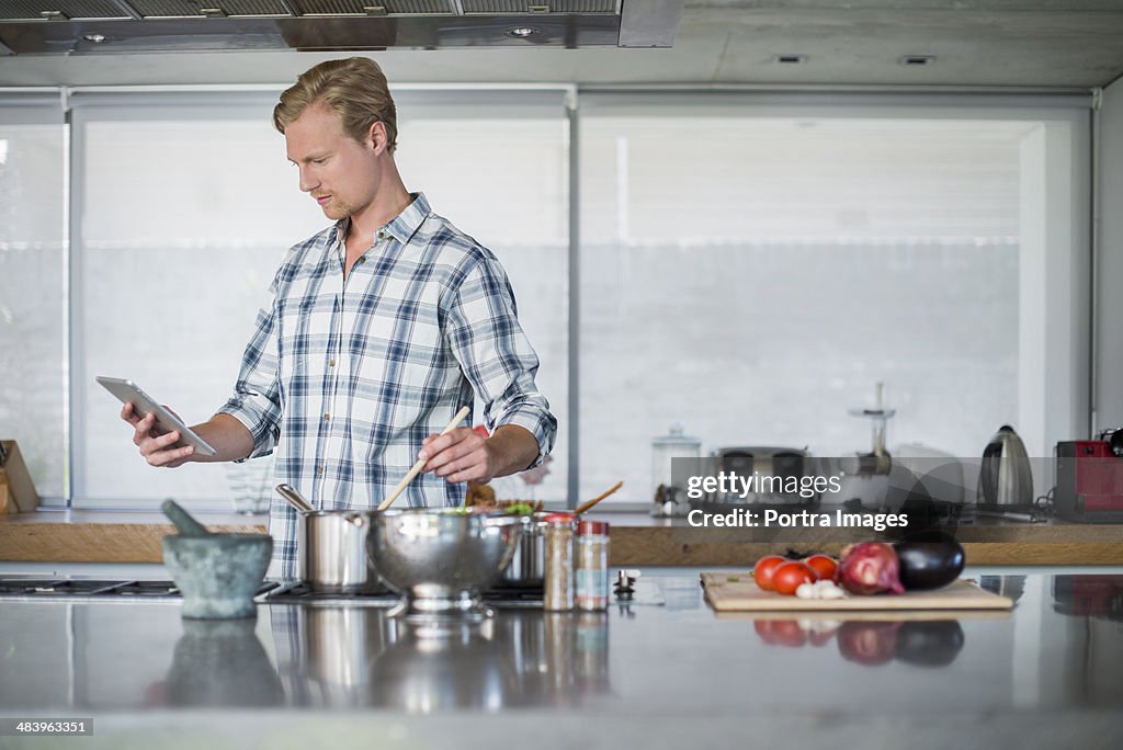 Man using a digital tablet in kitchen