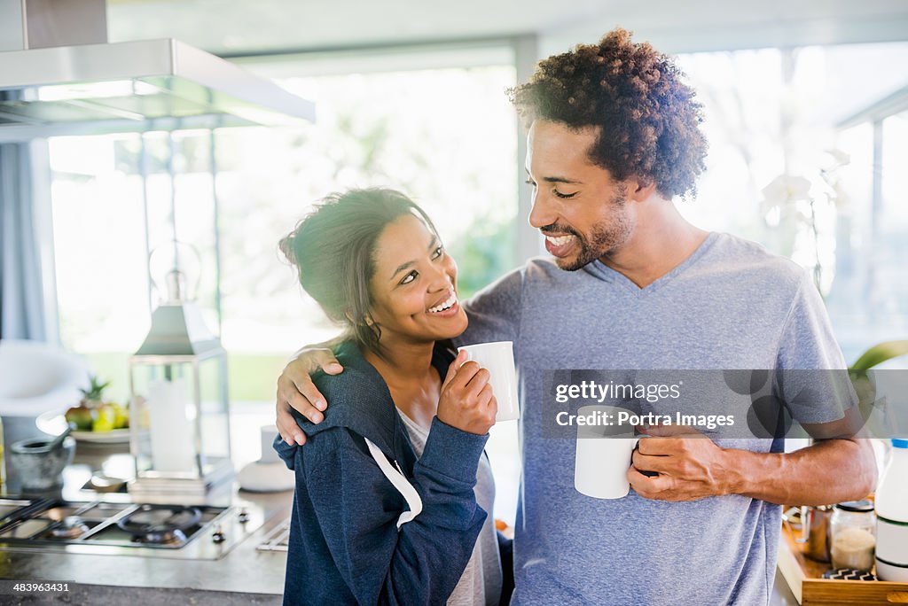Smiling couple embracing in the kitchen