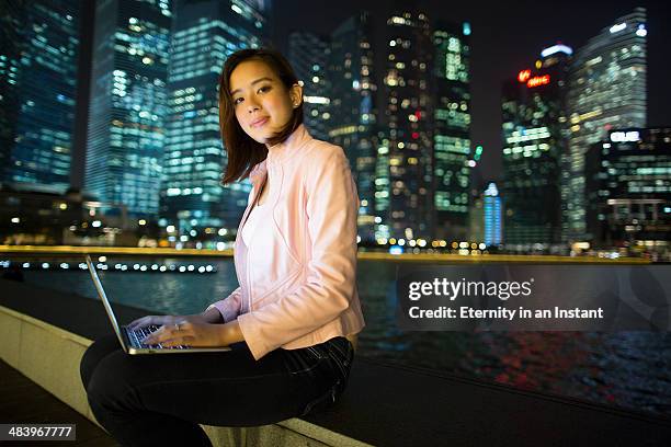 young woman in a city at night - singapore night stock pictures, royalty-free photos & images