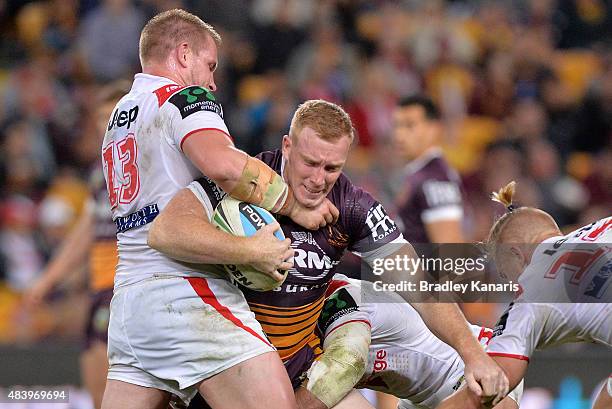 Jack Reed of the Broncos is tackled during the round 23 NRL match between the Brisbane Broncos and the St George Illawarra Dragons at Suncorp Stadium...