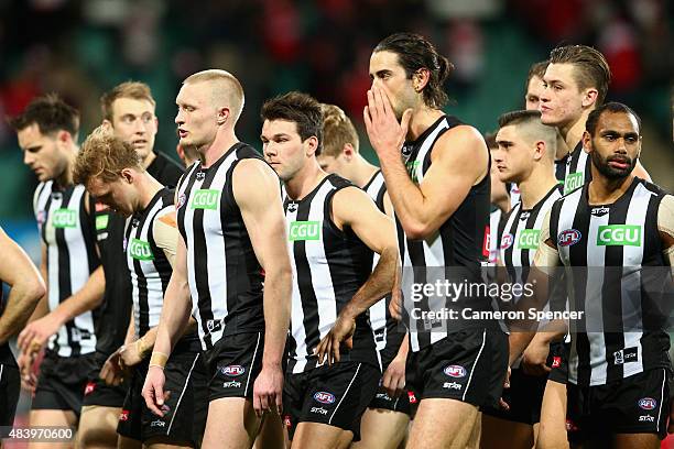 Jack Frost of the Magpies and team mates look dejected after losing the round 20 AFL match between the Sydney Swans and the Collingwood Magpies at...