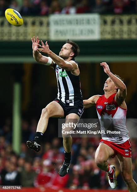 Nathan Brown of the Magpies takes a mark under pressure from Kurt Tippett of the Swans during the round 20 AFL match between the Sydney Swans and the...