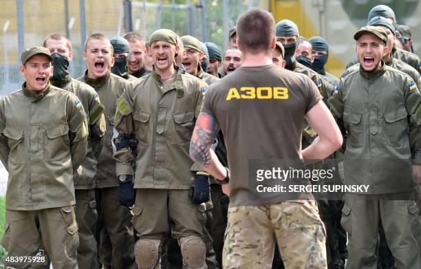 Recruits of the Azov far-right Ukrainian volunteer battalion shout slogans during a ceremony in Kiev, on August 14, 2015. Two people were killed in...