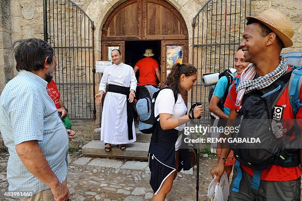 Father Guillaume Soury-Lavergne talks to visitors on August 12, 2015 outside the Benedictine abbey of Marcilhac-sur-Cele, in the Lot gorges, southern...