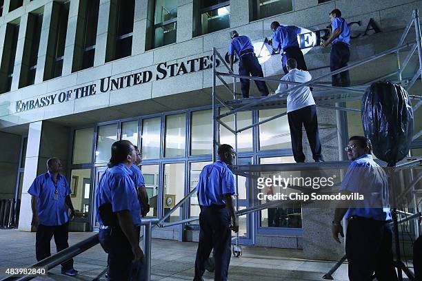 Embassy employees put the finishing touches on the sign above the entrance to the embassy building before sunrise August 14, 2015 in Havana, Cuba....