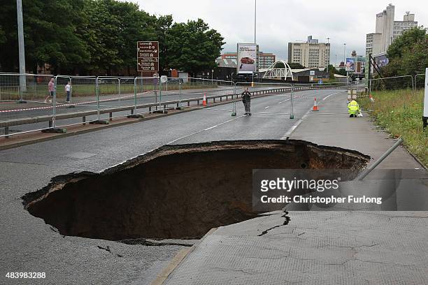 Sink hole appears on Mancunian Way in Manchester after heavy rain on August 14, 2015 in Manchester, England. Heavy rain and flood warnings have been...