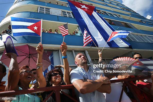 Hundreds of Cubans and visitors from other countries gather across the street from the newly reopened U.S. Embassy to observe the flag-raising...