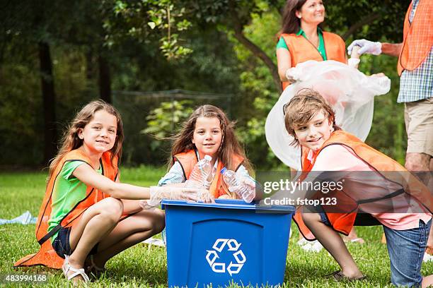 volunteers: family cleans up their community park. recycling bin. - school district stock pictures, royalty-free photos & images