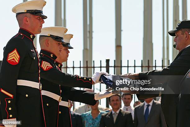 Three U.S. Marines accept the American flag from the three retired Marines who lowered the flag from in front of the U.S. Embassy in January of 1969...