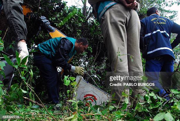 Rescue workers and policemen inspect the site where a police helicopter crashed in Limpio, Paraguay on August 14, 2015. A policeman died and two...
