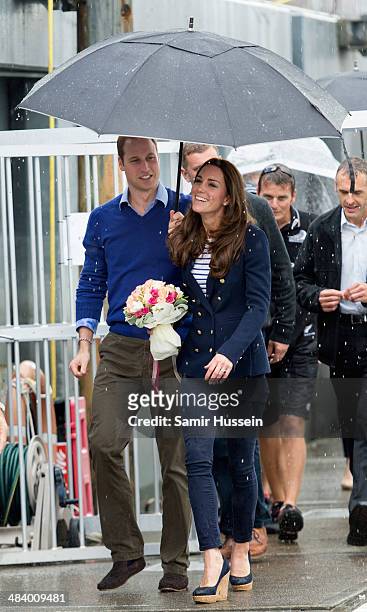 Prince William, Duke of Cambridge holds an umbrella up for Catherine, Duchess of Cambridge ahead of going sailing during their visit to Auckland...