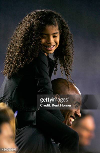 Los Angeles Laker Kobe Bryant stands on the sideline with his daughter Gianna Maria-Onore Bryant on his shoulders prior to the start of the game...
