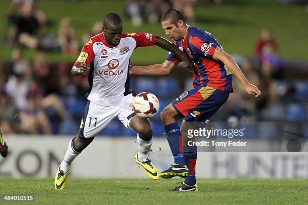 Bruce Djite of Adelaide contests the ball with Josh Mitchell of the Jets during the round 27 A-League match between the Newcastle Jets and Adelaide...