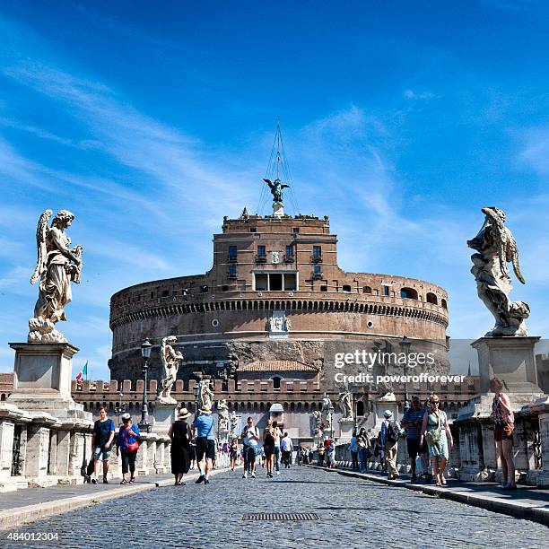 tourists walking by castel sant'angelo in rome, italy - sant angelo stockfoto's en -beelden