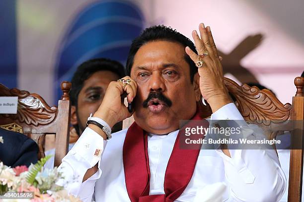 Former Sri Lankan president and parliamentary candidate Mahinda Rajapaksa talks on phone during his party's rally on the final day of election...