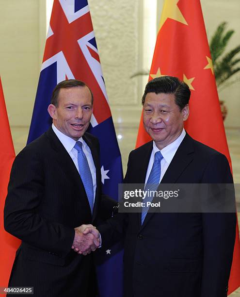 Chinese President Xi Jinping shakes hands with Australian Prime Minister Tony Abbott before a meeting at the Great Hall of the People on April 11,...