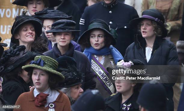 Actors Anne-Marie Duff, Carey Mulligan, Helena Bonham Carter and Romola Garai keep warm during a break in filming of the movie Suffragette at...