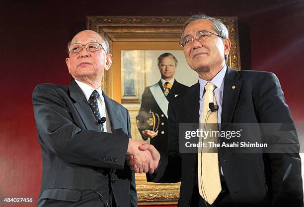 Nobel Prize in Chemistry laureates Akira Suzuki and Eiichi Negishi shake hands duringa press conference at the Japanese Embassy ahead of the Nobel...