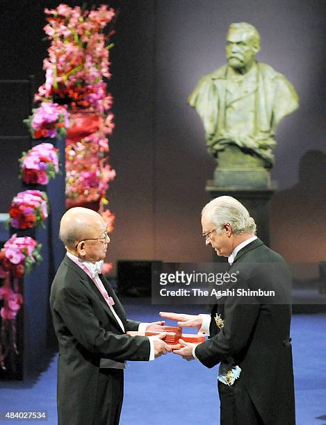 Nobel Prize in Chemistry laureate Akira Suzuki receives the medal from the King Carl XVI Gustaf of Sweden during the Nobel Prize Award Ceremony on...