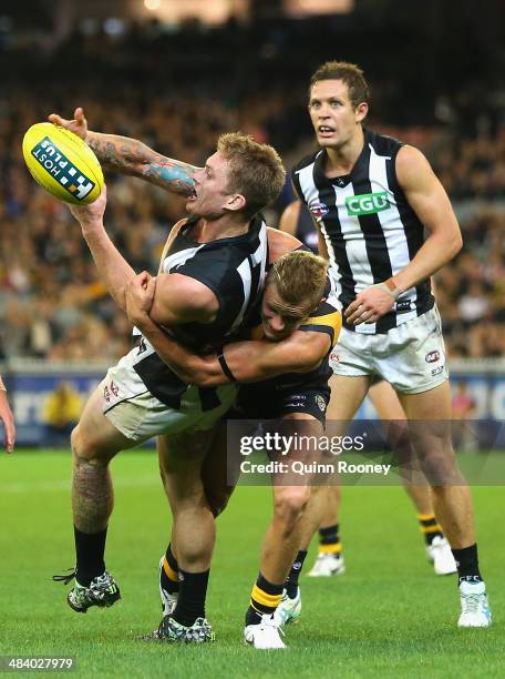 Dayne Beams of the Magpies handballs whilst being tackled by Brandon Ellis of the Tigers during the round four AFL match between the Richmond Tigers...