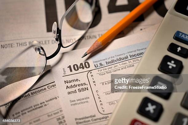 filing taxes on irs form 1040 close-up view - filing documents stock pictures, royalty-free photos & images