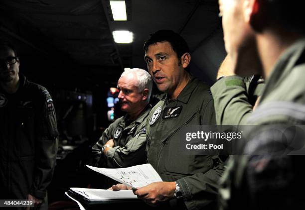 Royal New Zealand Air Force Tactical Coordinator Brent Collier briefs the crew aboard a P3 Orion maratime search aircraft before take-off towards the...